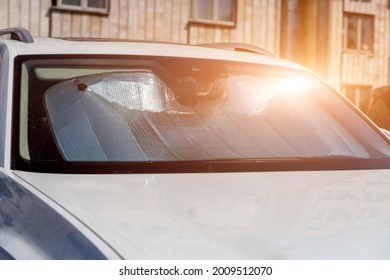 Sun Visor Or Sun Reflector On Car Windshield Protects Car In Parking Lot. There Is Light From Sun Shining On Windshield