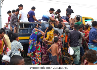 Sunamganj, Sylhet Division, Bangladesh - 21 June 2022: Flood victims collect food from a relief vehicle.