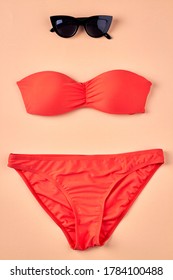 Sunbath Suit And Sunglasses. Orange Swimsuit. Top View Flat Lay.