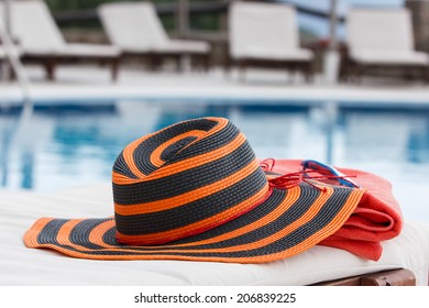 Sunbathing accessories. Sunbathing accessories on beach towel by a swimming pool - Powered by Shutterstock