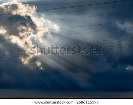 Sunbeams break through the dark cloudy sky