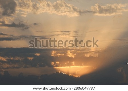 Sunbeams breaking through clouds at golden hour, crepuscular rays