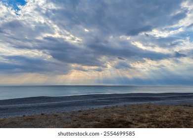 Sunbeams Breaking Through Clouds Over Tranquil Sea
