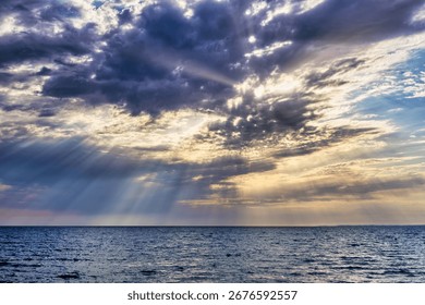 Sunbeams Breaking Through a Dramatic and Cloudy Sky Over the Sea