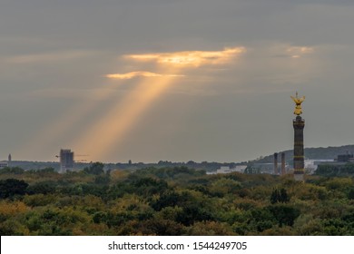 Sunbeams filter through the clouds on the Tiergarten Park in Berlin, Germany, near the Victory Column
