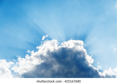 sunbeams over dramatic cloud in blue sky