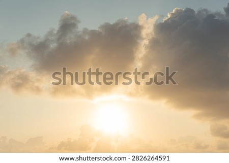 The sunbeams pierce through dramatic clouds during a vibrant sunset over the sea, casting a warm golden glow across the sky. This atmospheric scene evokes peace and natural beauty. [Location unspecified], [Country unspecified].