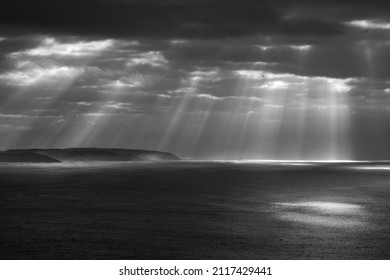 Sunbeams shining through the clouds during a storm over the ocean - Powered by Shutterstock - Get 15% off with code: PIKWIZARD15