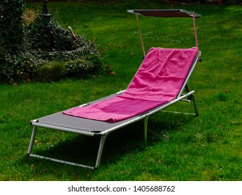 Sunbed With Pink Towel In The Garden