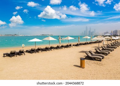 Sunbeds and umbrellas at the beach of luxury hotel in Abu Dhabi in a summer day, United Arab Emirates