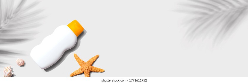 Sunblock bottle starfish and seashells - flat lay