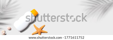 Sunblock bottle starfish and seashells - flat lay