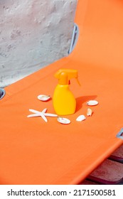 Sunblock Cream And Sea Shells On Orange Sunbed 