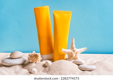 Sunblock lotion bottles, starfish, sea shells and sunglasses on blue background with beach sand, copy space. Summer beach, vacation concept, spf uv-protect cosmetics. - Powered by Shutterstock