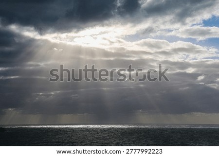 Sunburst through rainclouds over the ocean near Margaret River in Western Australia