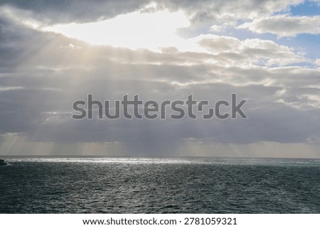 Sunburst through rainclouds in the sky over the ocean near Margaret River in Western Australia