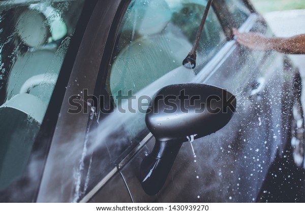 Sunday car wash. Man
washing his car.