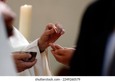 Sunday mass in a catholic parish. Priest giving Holy Communion.
 Catholic church.  France.