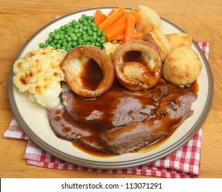 Sunday Roast Beef Dinner With Yorkshire Puddings, Vegetables And Gravy.