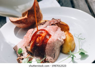 Sunday Roast With Marinated Lamb Rump, Beef Dripping Roast Potatoes, Yorkshire Puddings, And Gravy. Traditional Food In English Pub