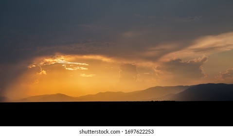 Sundown over the mountains. Dramatic sky and clouds in the golden hour.