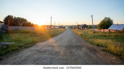 Sun-drenched Ground Road Leading To River In Village In Russia. Countryside At Sunset. Local Travel. Staycation.