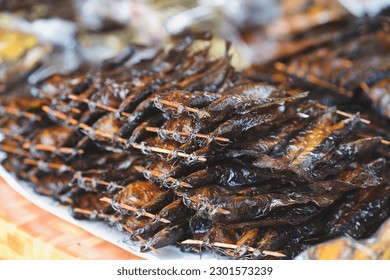 Sun-dried catfish skewers stacked on top of food stalls. Thai traditional food. Selective focus.