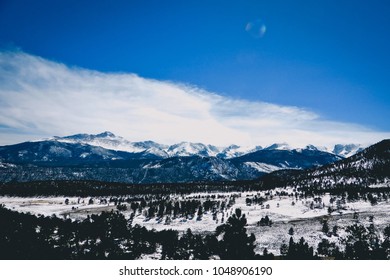 Sunflare Over Windy, Snowy Mountaintops