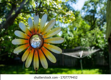 Sunflower Decoration Hanging From Porch Awning On Bright And Sunny Summer Day. Yellow And Orange Pedals With Diamond Reflective Center. 