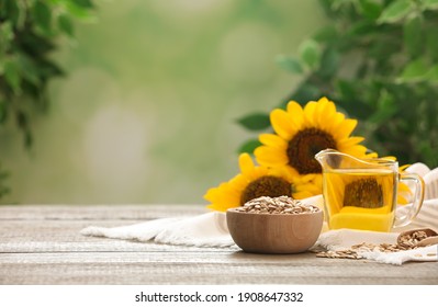 Sunflower oil and seeds on wooden table against blurred background, space for text