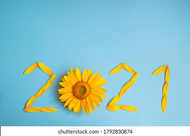 Sunflower Petals In The Form Of Numbers 2021 On A Blue Background. 2021 New Year New Reality. Summer It Is Time For Traveling