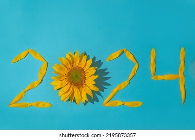 Sunflower petals in the form of numbers 2024 on a blue background. 2024 new year new reality. Summer it is time for traveling - Shutterstock ID 2195873357