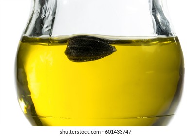 Sunflower Seeds Are Floating In Sunflower Oil In A Round Glass Jar. On A White Background.