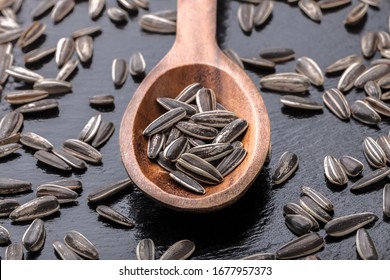 Sunflower Seeds Overhead Large Organic Roasted And Salted Close-up Arrangement In Old Brown Wooden Kitchen Spoon On Black Shiny Stone Background In Studio