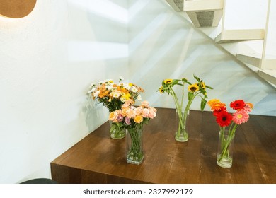 Sunflowers and rose in glass vase on wooden table. - Powered by Shutterstock