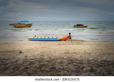 Sungai Danau, Indonesia : Two Small Children Play Around A Banan Boat On A Beach In Sungai Danau, Indonesia (03-03-2019).