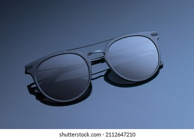 Sunglasses close  up dark gray glossy background  Women's black glasses and gradient  Polarized round lenses eyeglass  Plastic frame 