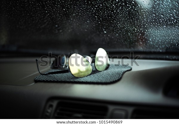 Sunglasses coated mercury in car with raindrop on\
the car’s front\
glass