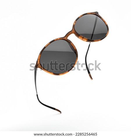 Sunglasses in flying isolated on white and grey background. Sunglasses summer woman fashion accessories as design element for promo or advertising banner. Glasses black leopard color with vintage