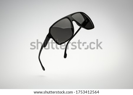 Sunglasses of flying on white and grey background. Sun glasses summer man accessories as design element for promo or advertising banner