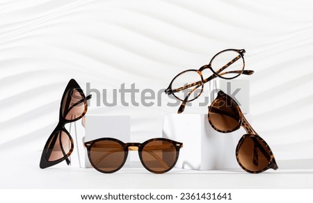 Sunglasses and glasses sale concept. Trendy sunglasses on podiums on white background. Trendy Fashion summer accessories. Copy space. New eyewear collection. Optic store sale, discount poster