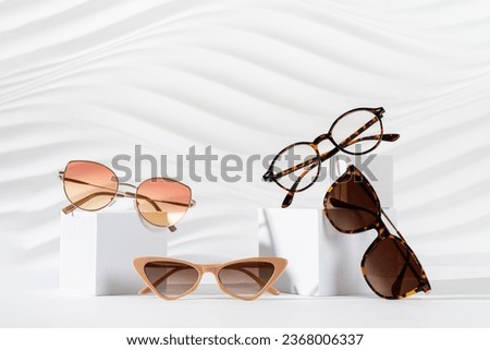 Sunglasses and glasses sale concept. Trendy sunglasses on podiums on a white background. Trendy Fashion summer accessories. Copy space for text. Promotion, sale. Optic store discount poster