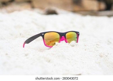 Sunglasses lying on sand with a reflection of the beach. - Shutterstock ID 283043072