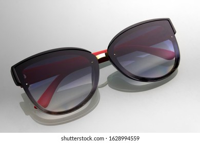 Sunglasses background gray gradient and shadow reflection  Black glasses and red ears  Accessory for relaxation   walking sunny days 