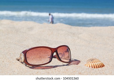 Sunglasses on the beach and shells.