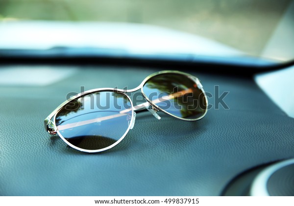 Sunglasses on car panel,\
closeup