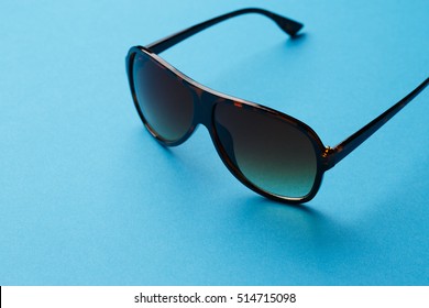 Sunglasses on empty blue background
