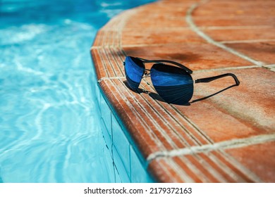 Sunglasses On Side Of Pool With Clear Turquoise Water. No People Copy Space