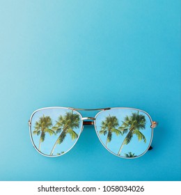 Sunglasses With Palm Trees Reflected In Them And Space For Text, Top View