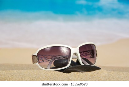 Sunglasses and pebbles on sand - Powered by Shutterstock